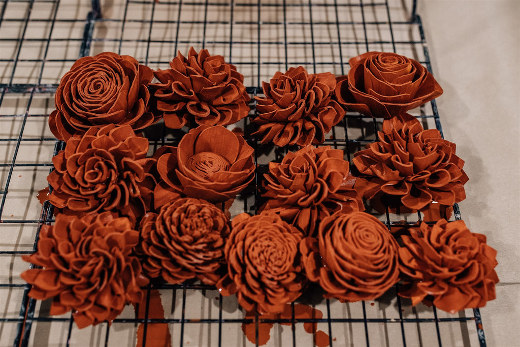 A rack of freshly painted sola wood flowers in the color 